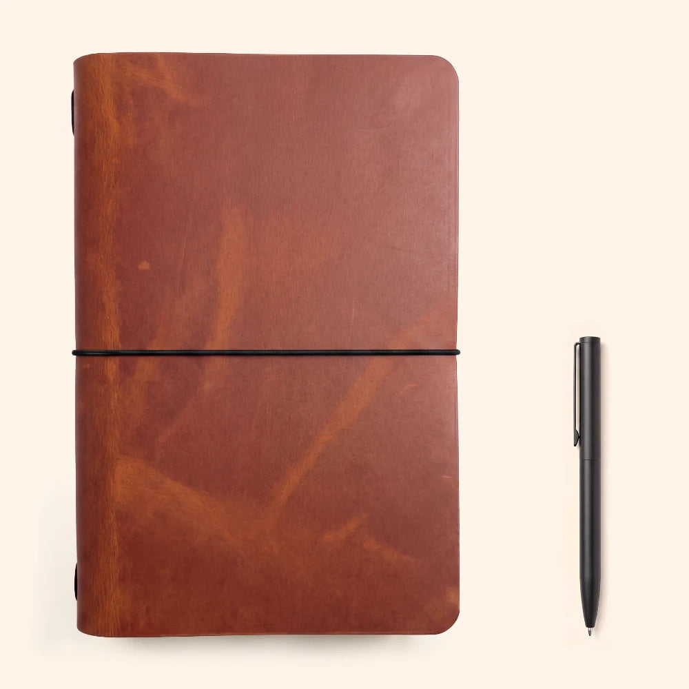 Simple leather journal cover displaying natural grain and an uncomplicated writing insert.