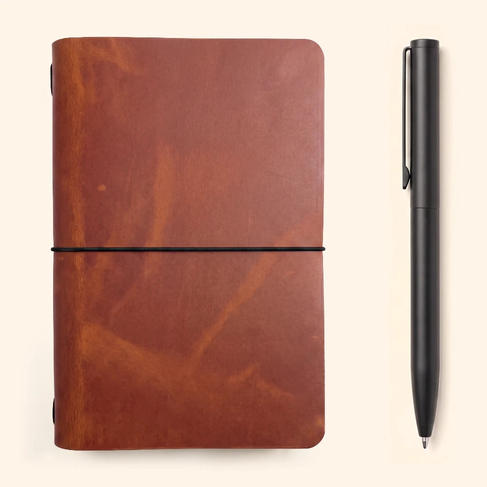 Simple handmade leather cover with plain notebook pages and one interior elastic.