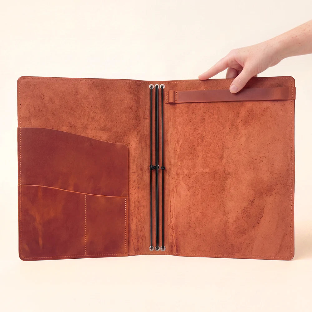 Open natural leather cover showing three elastic retainers and functional storage spaces.