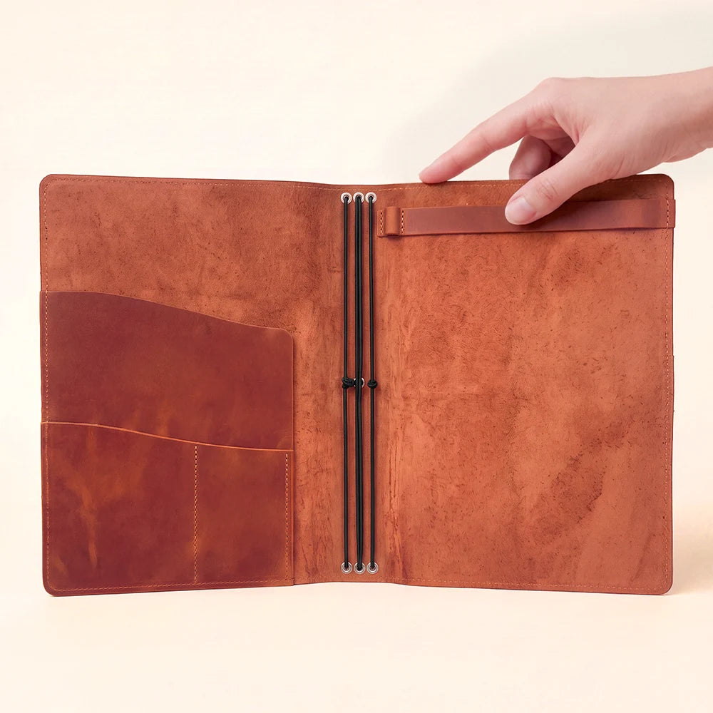 Natural leather journal case opened to reveal pockets and a practical refill system.