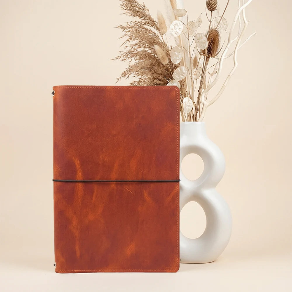 Handmade leather sketchbook portfolio with refillable notebook support and inner organization.