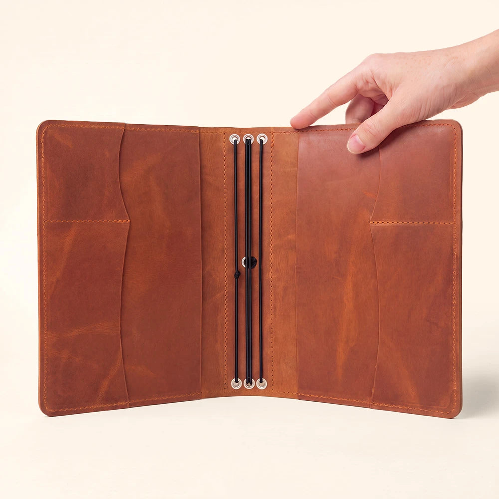 Leather notebook holder with functional storage pockets for documents and everyday accessories.