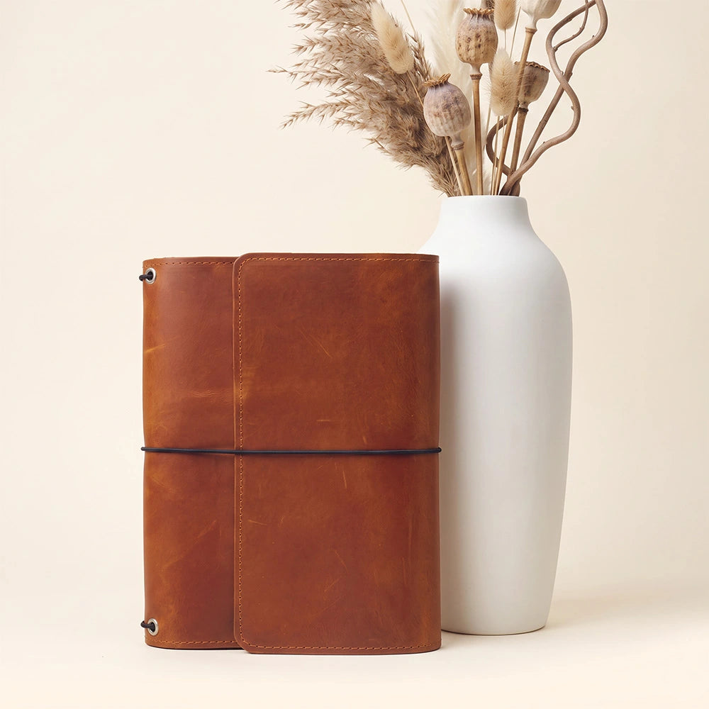 Premium handcrafted leather planner cover with interior organizer and writing accessory holder.