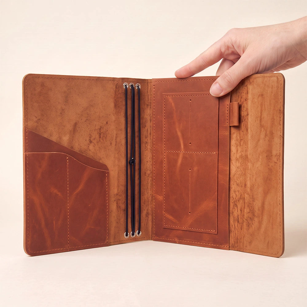 Premium leather notebook cover with inner storage pockets and elastic pen loop included.