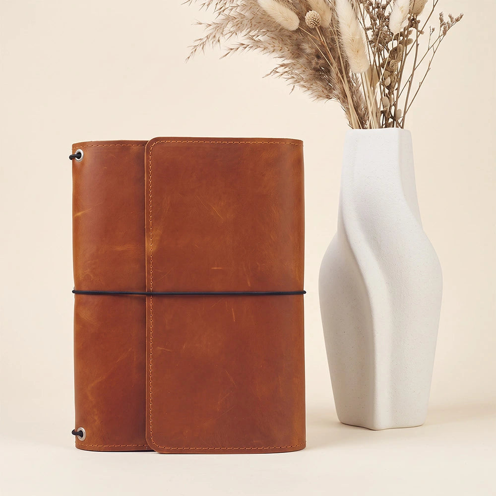 Elegant refillable notebook cover crafted from genuine leather with interior organization pockets.