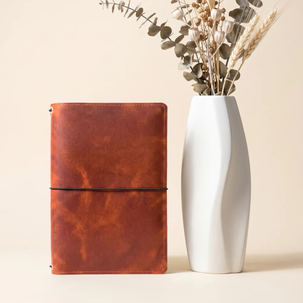 Handmade leather sleeve featuring three flexible inner cords for notebook inserts.