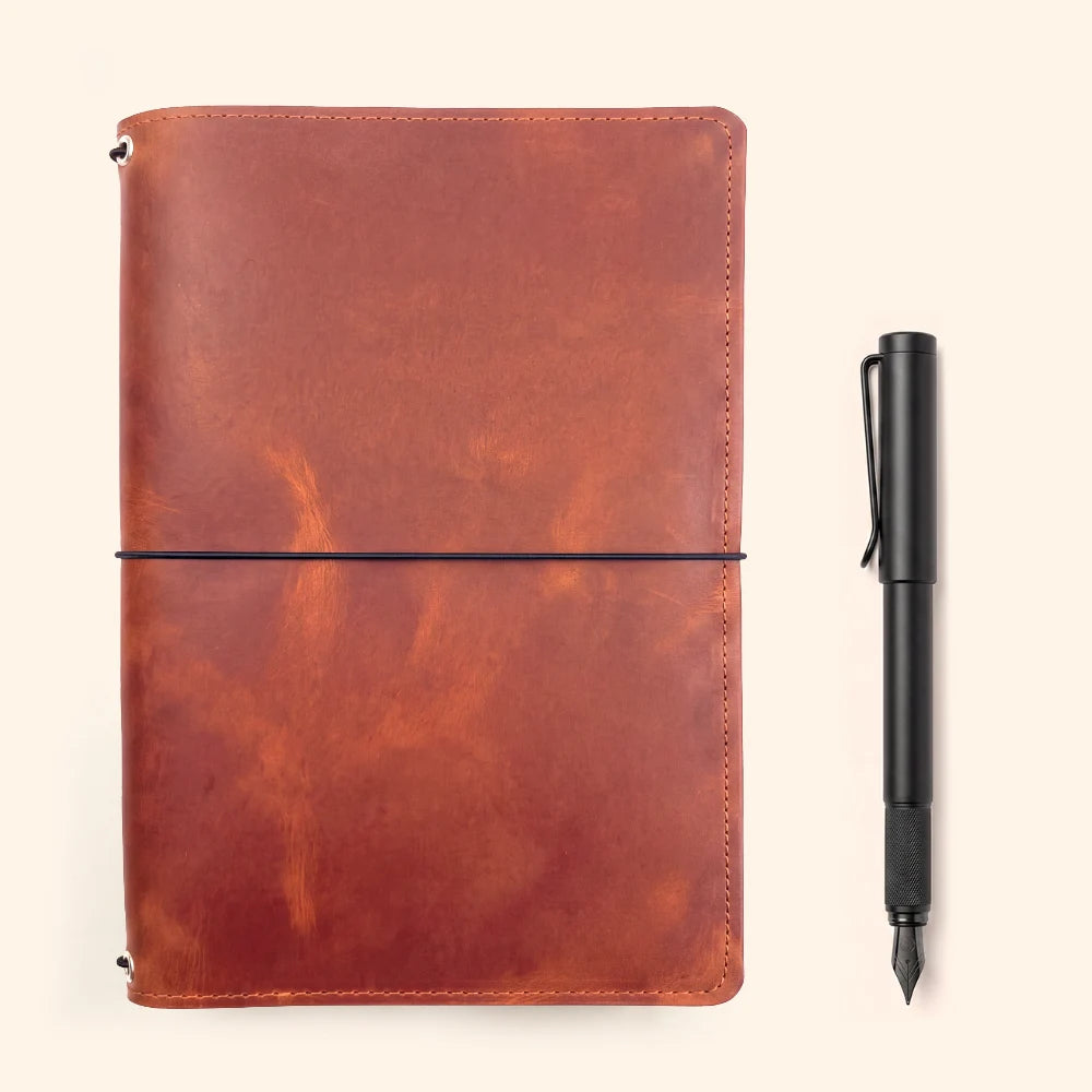 Handmade leather organizer with three elastic attachment points for notebook refills.