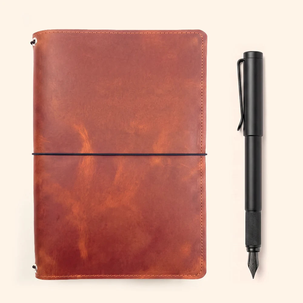 Handmade leather journal holder with three elastic loops for flexible refill organization.