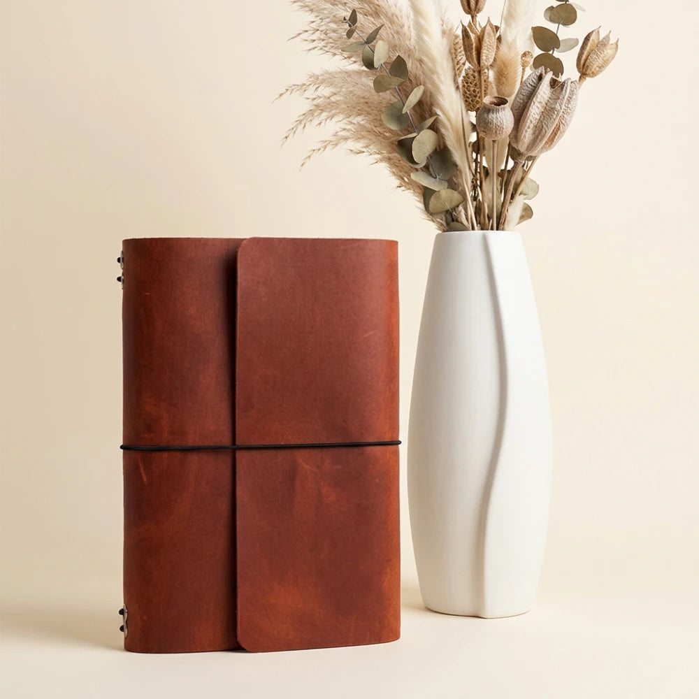 Handmade leather travel journal organizer supporting six inserts with flexible elastic straps.