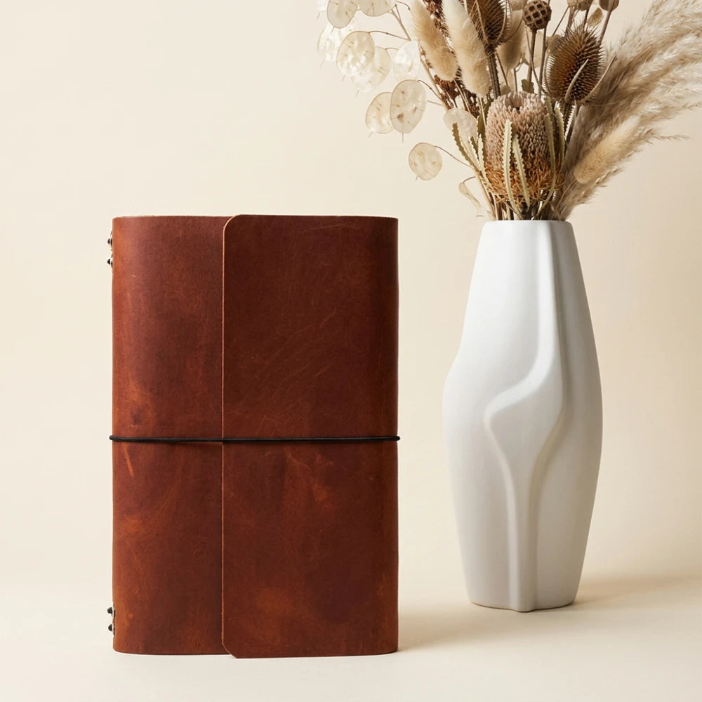 Genuine leather notebook wrap with six stretch retainers for multiple writing inserts.