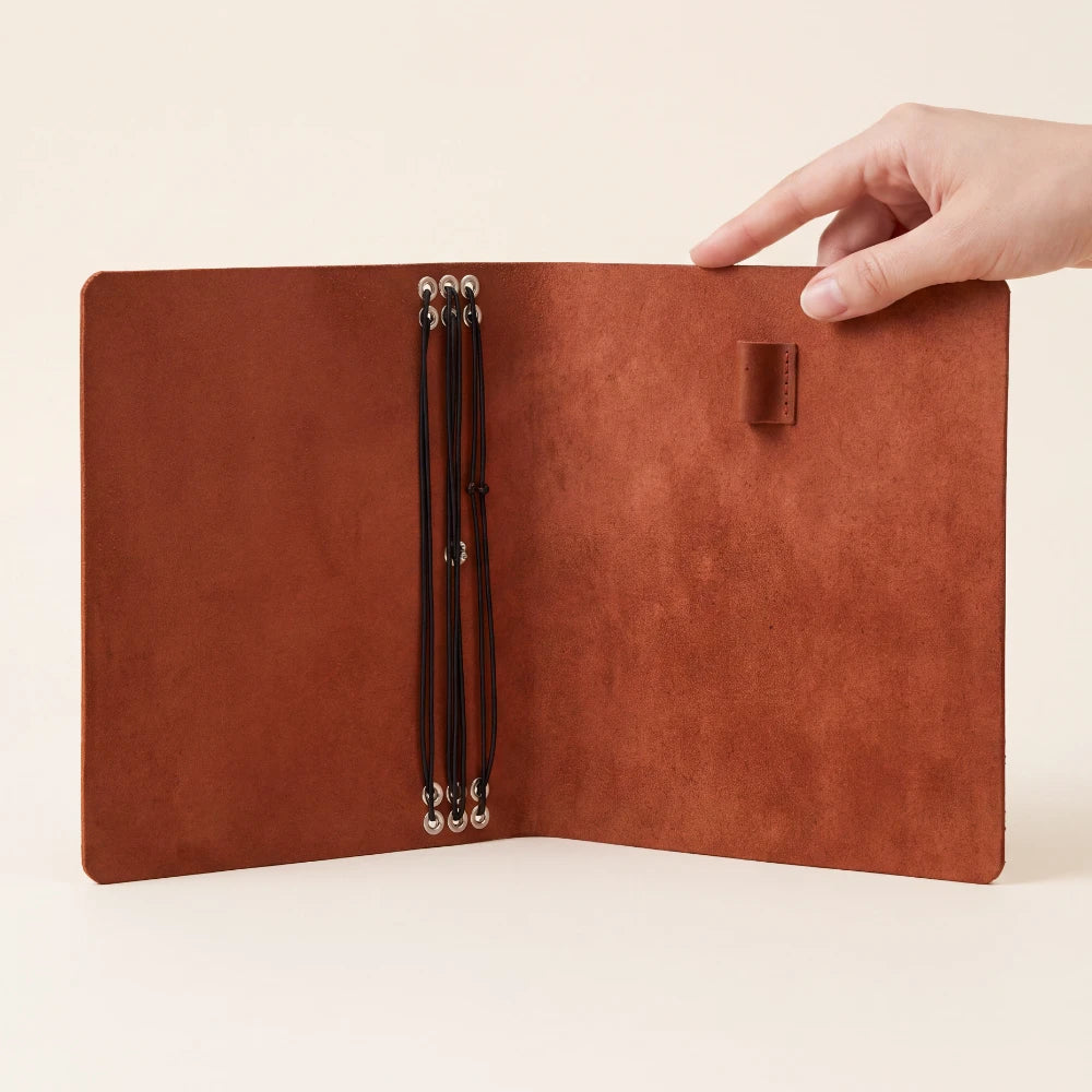 Refillable genuine leather journal holder designed to securely organize six inserts.