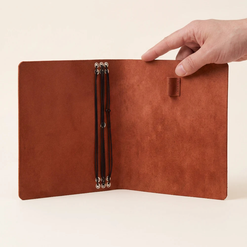 Natural leather notebook organizer with six elastic straps and a convenient pen loop.