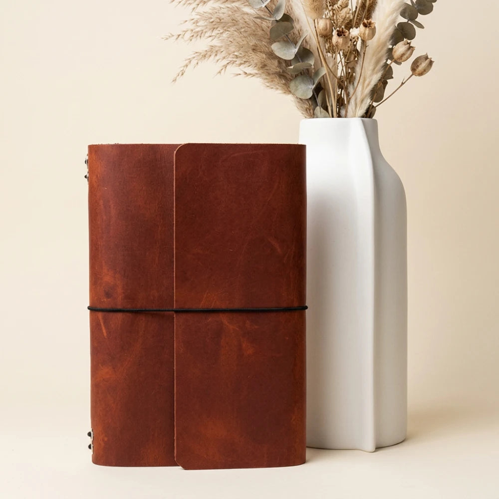 Refillable notebook cover crafted from leather with six flexible interior elastics.