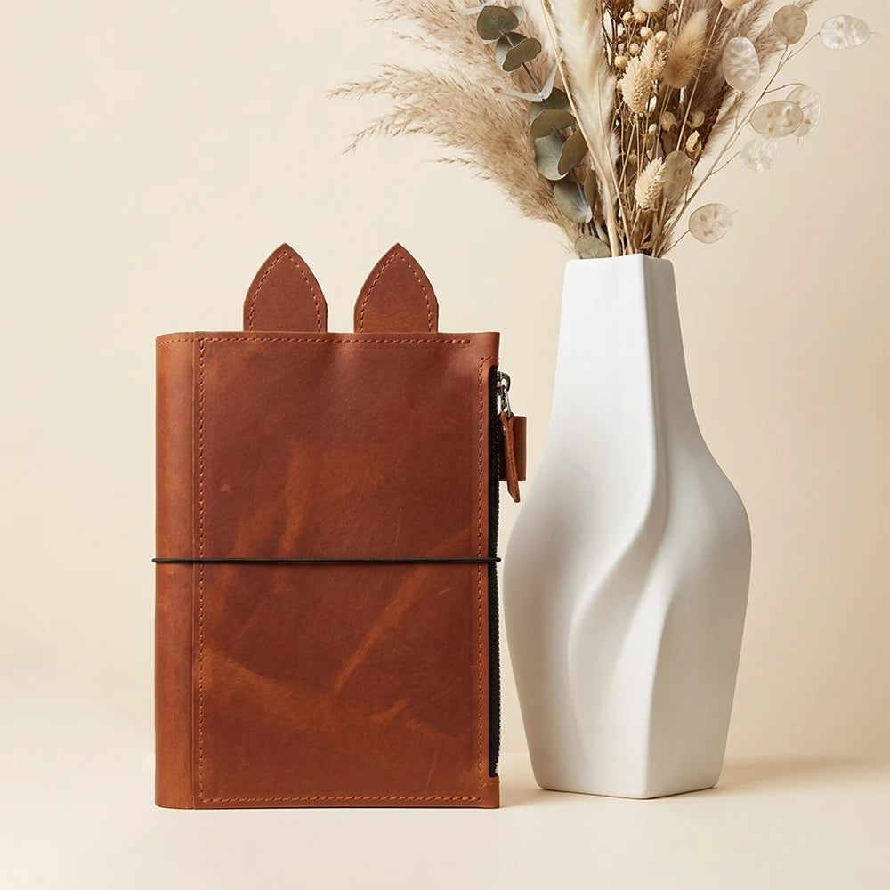 Handmade genuine leather planner case opened flat to display its functional features.