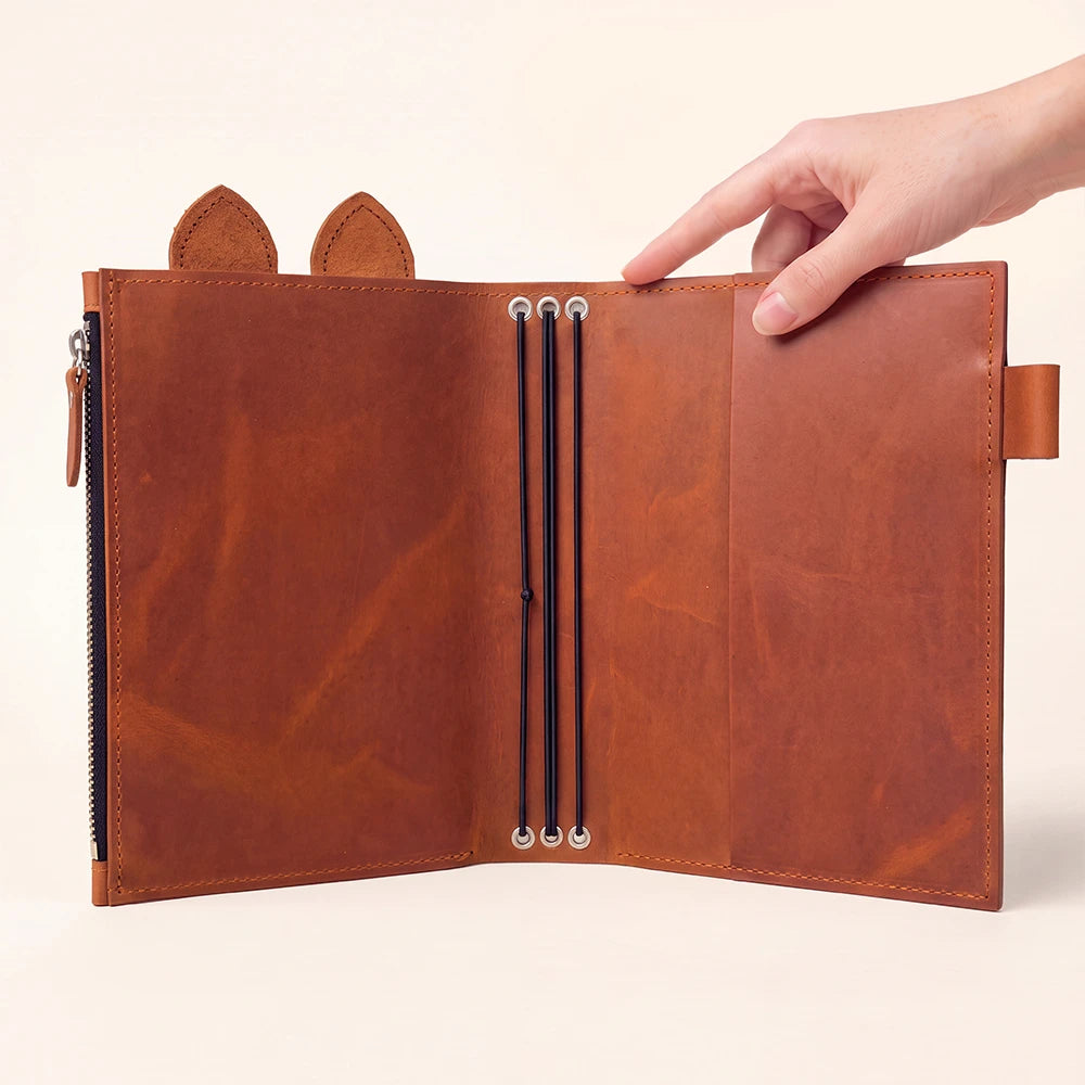 Handcrafted journal cover with roomy zipper section and integrated leather pen holder.