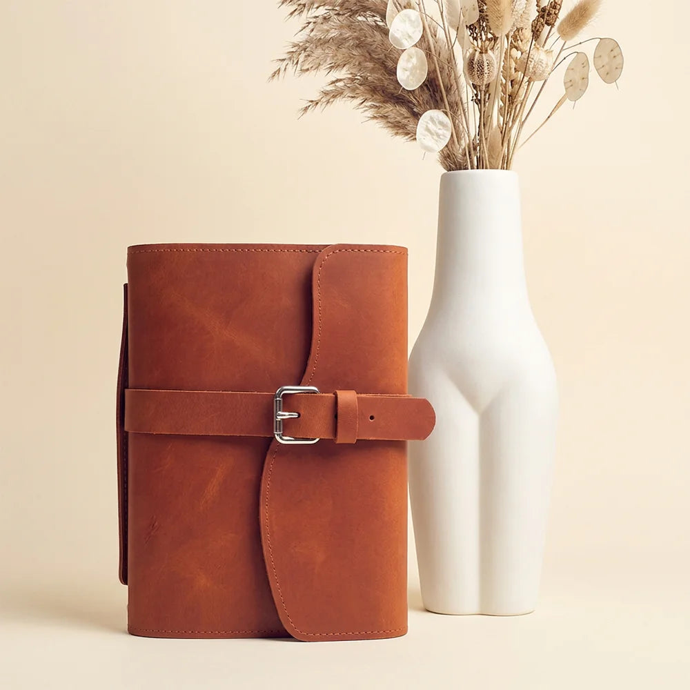 Genuine leather notebook sleeve featuring useful storage pockets, pen loop, page marker, and outer handle.