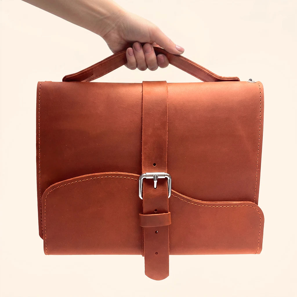 Minimalist travel notebook cover made from natural leather with three elastic bands.