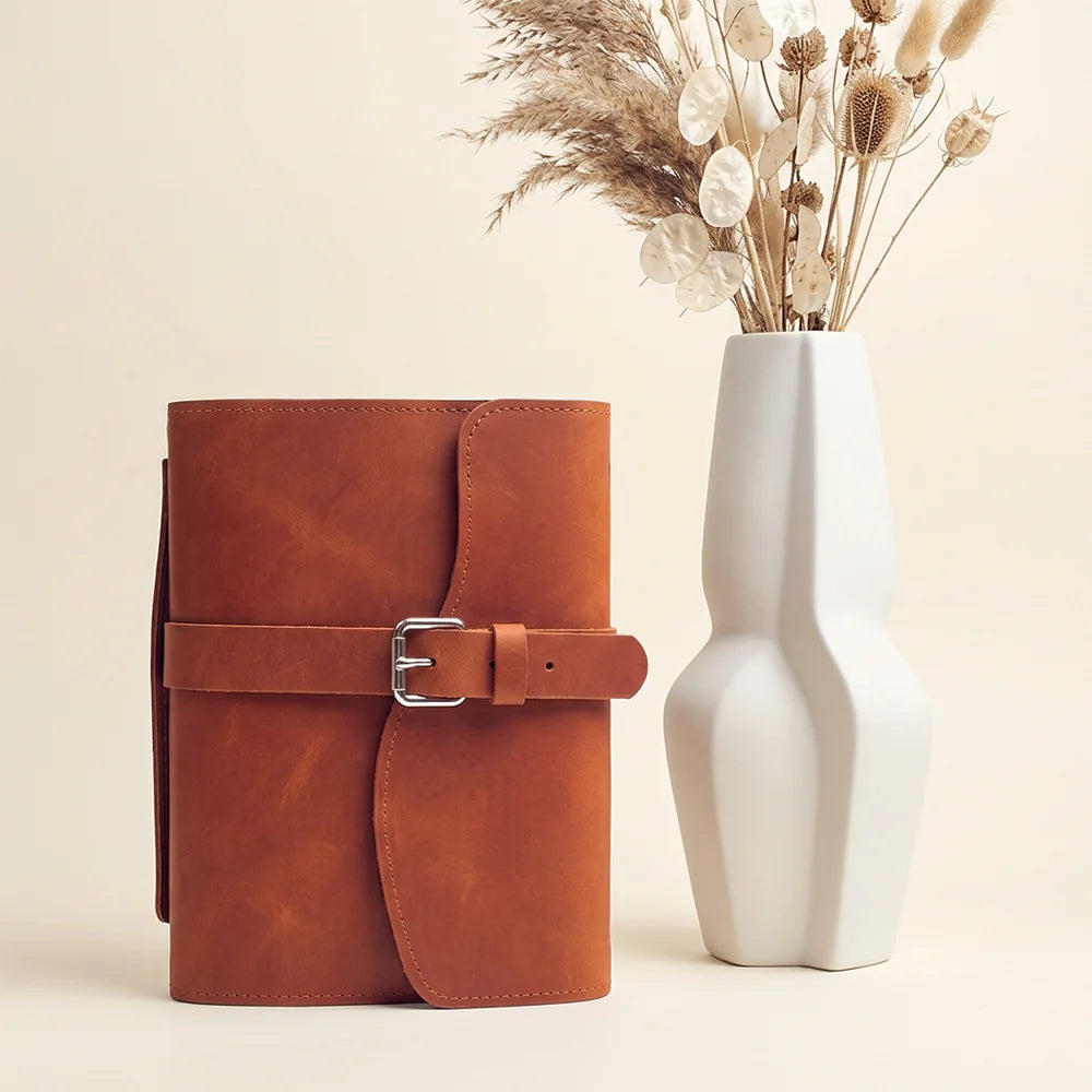 Genuine leather notebook case combining organized pockets, pen holder, built-in bookmark, and functional outer handle.