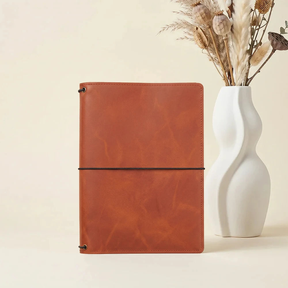 Leather notebook cover with minimalist design and functional interior card compartments.