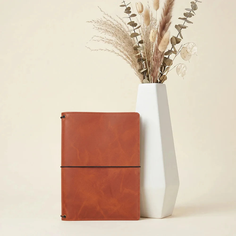 Genuine leather journal cover featuring three elastic bands and practical interior card pockets.