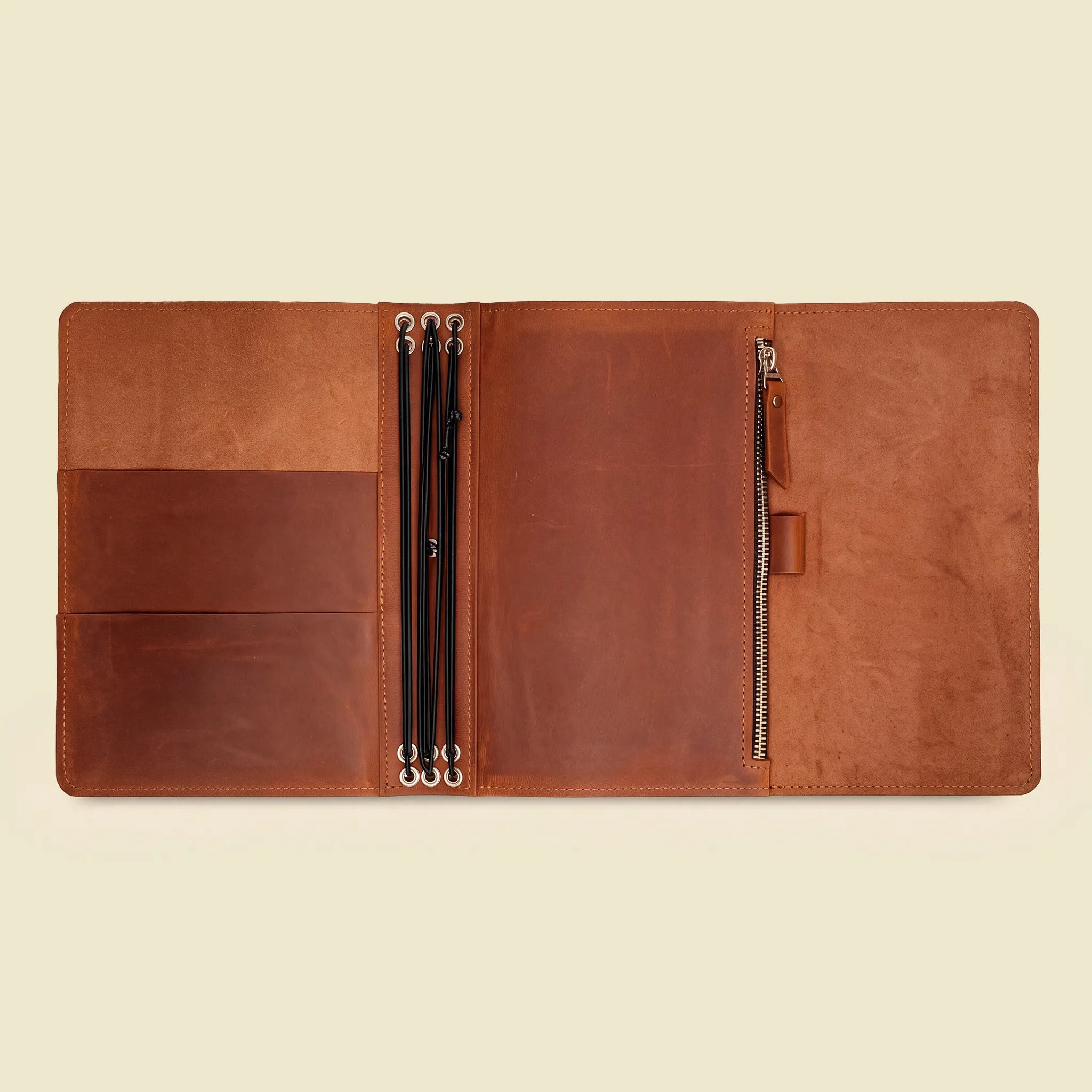 Genuine leather journal portfolio with elastic cords and compartments for paper essentials.
