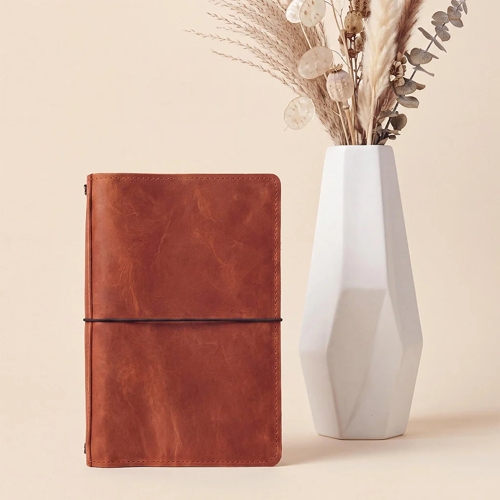 Genuine leather refillable journal organizer with secure elastic bands and storage compartments.
