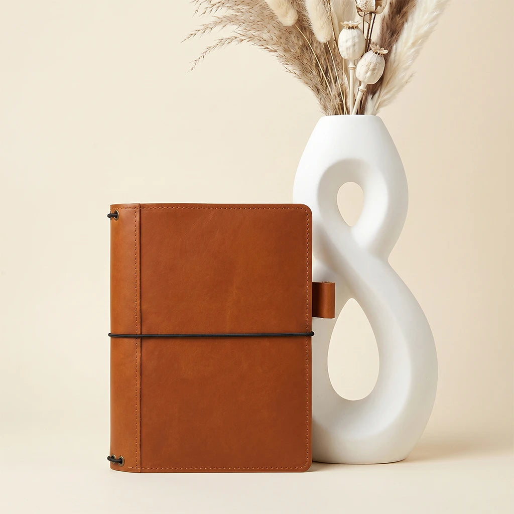 Leather journal cover featuring five elastic bands, interior pockets, and pen loop