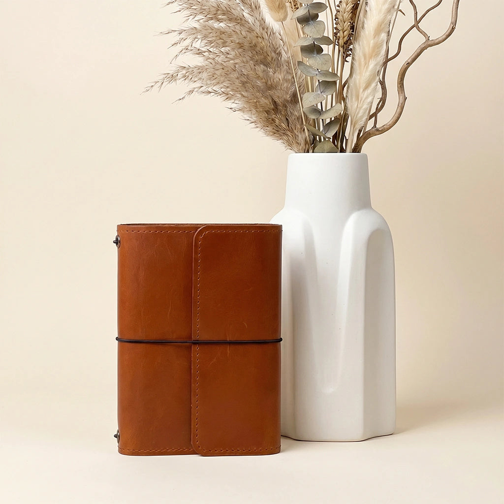 Handcrafted leather notebook portfolio featuring refillable elastic system and organizer compartments.