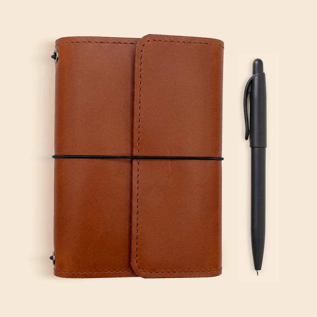 Genuine leather notebook wrap with elastic journal bands and interior storage pockets.