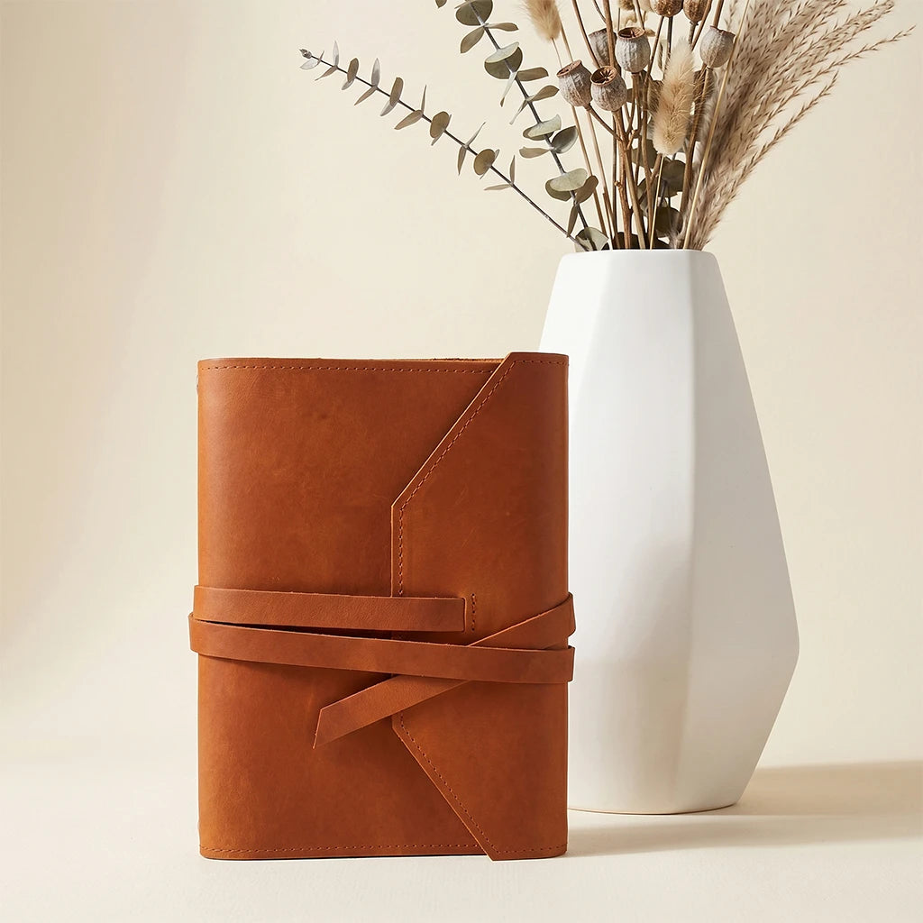 Refined leather notebook holder combining organization, portability, and secure closure.