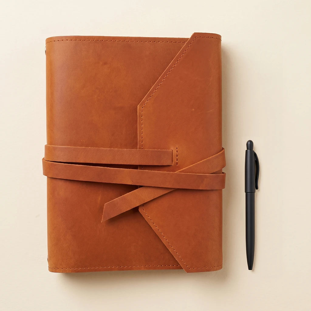 Handmade notebook cover crafted from leather with dedicated pen carrying loop.