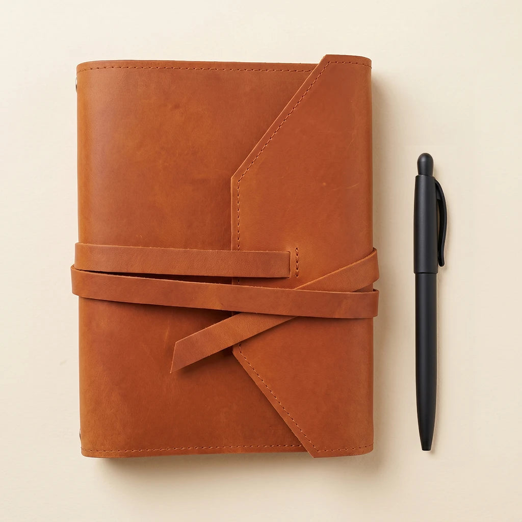 Handmade leather organizer for notebooks featuring elastic straps and pen space.