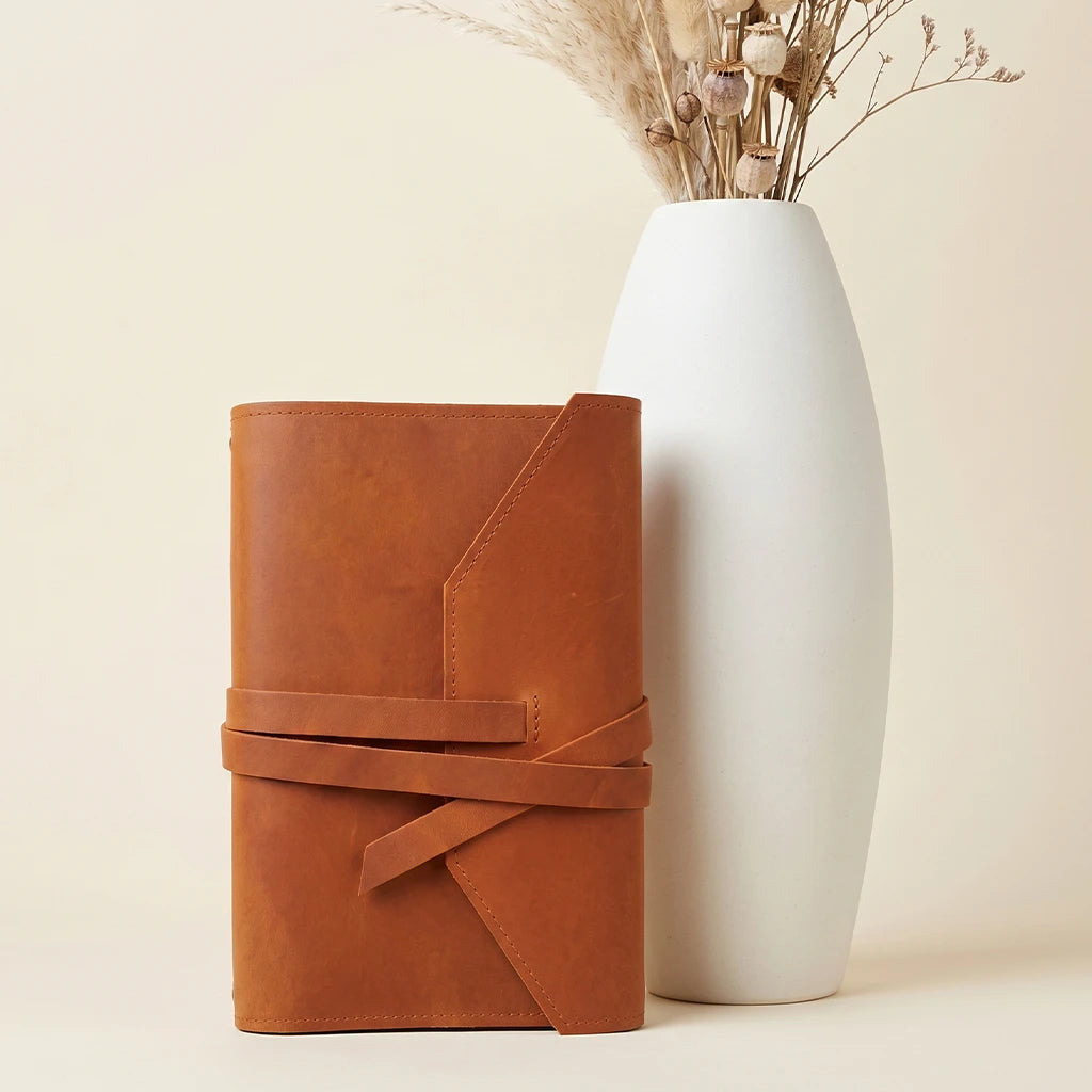 Refillable leather notebook organizer with elastic straps and practical writing tool loop.