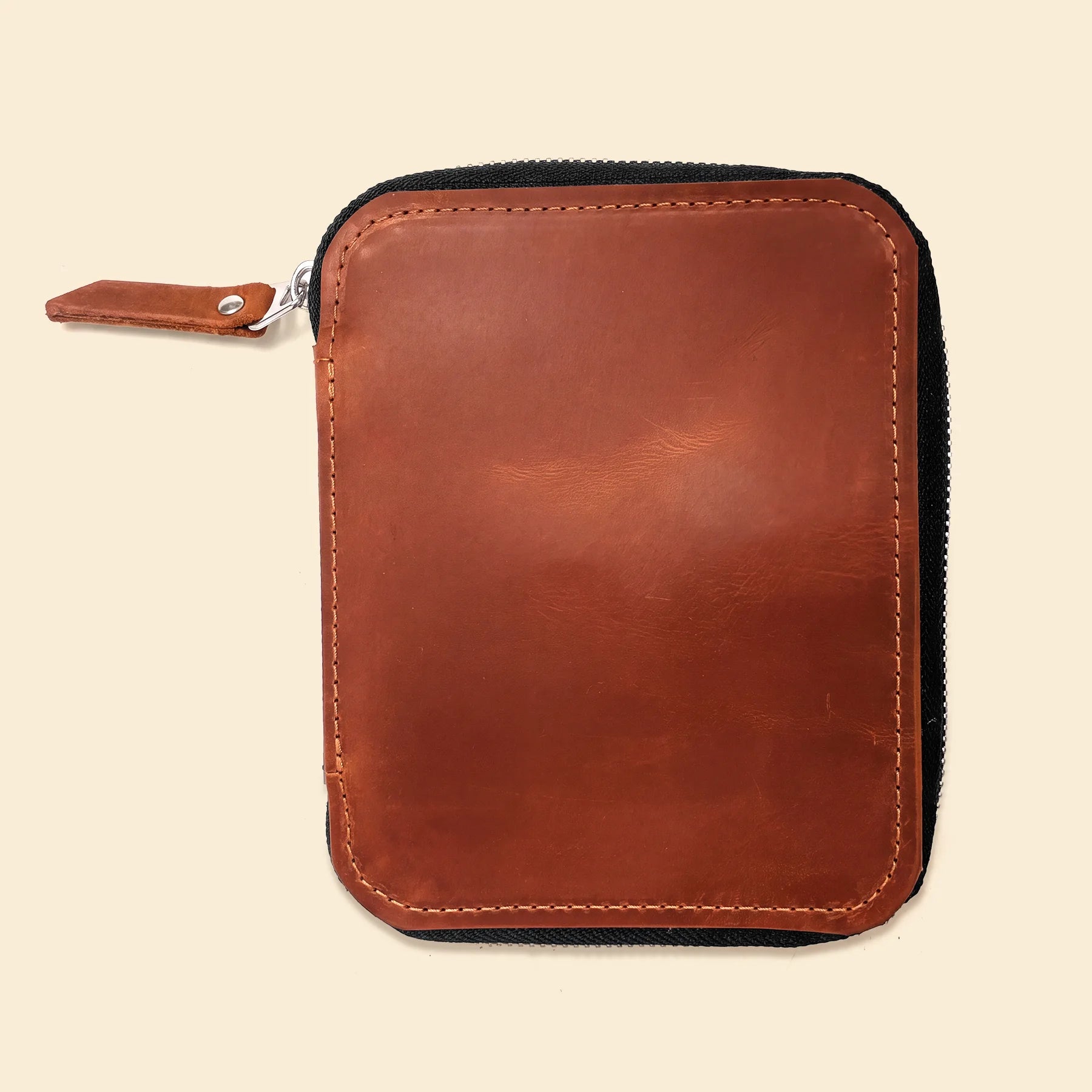 Brown leather pencil pouch featuring secure zipper and minimalist handcrafted design.