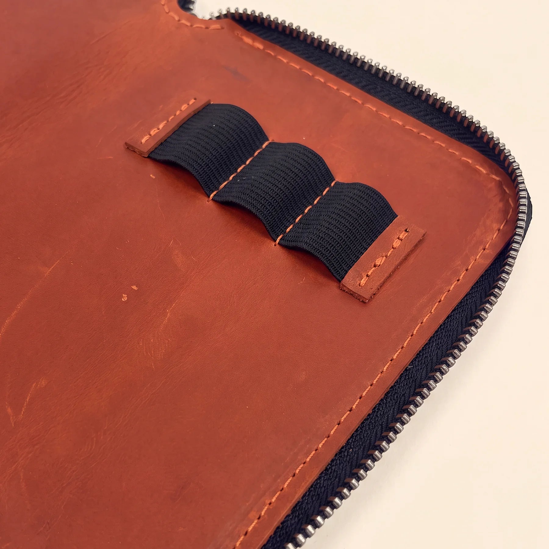 Genuine leather stationery case with zipper for organized pens during travel.