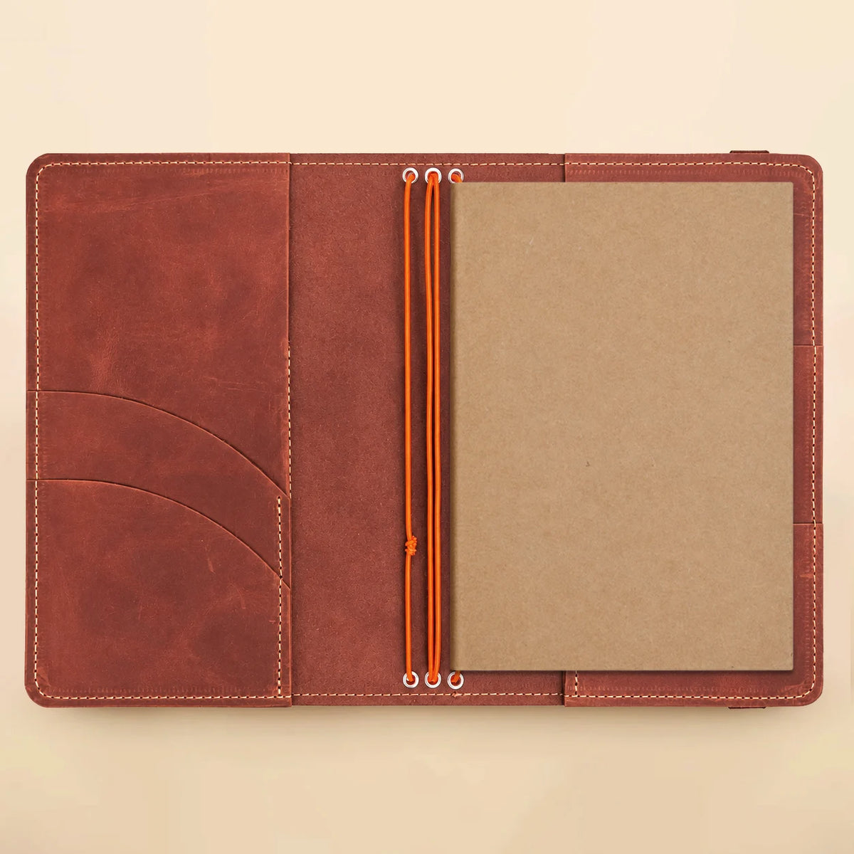 Natural leather notebook organizer featuring three stretch bands, multiple pockets, and a clear window for photographs.