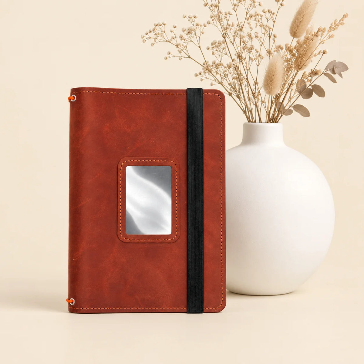 Leather notebook cover made from natural leather with three elastic bands and storage pockets.