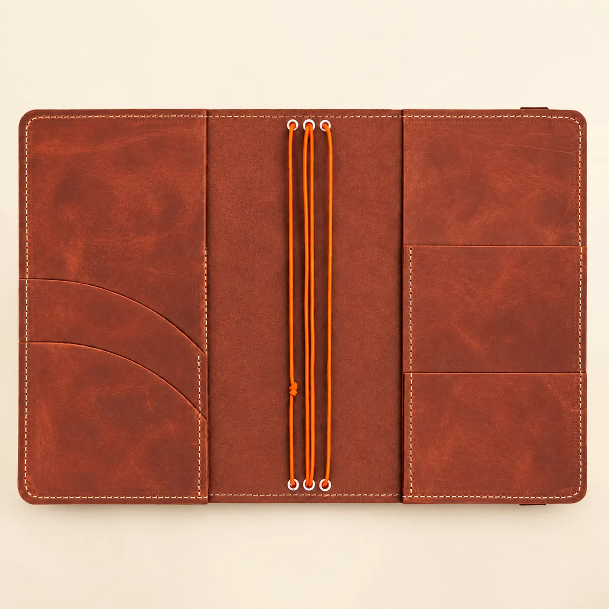 Handmade natural leather cover showing three notebook bands and practical pockets for essentials.