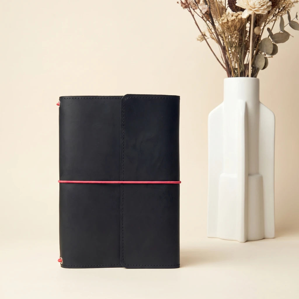 Leather journal accessory case with elastic closure and integrated pen holder detail