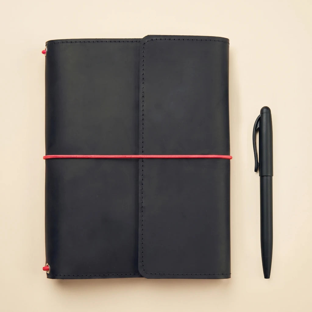 Handmade leather journal keeper with elastic fastening and organized storage interior