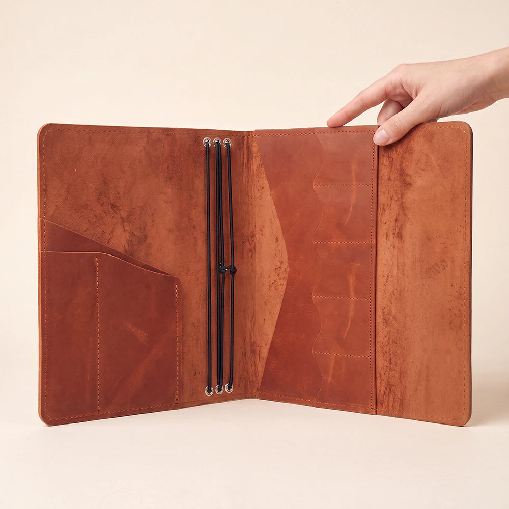 Premium refillable notebook sleeve with durable leather construction and elastic journal holders.