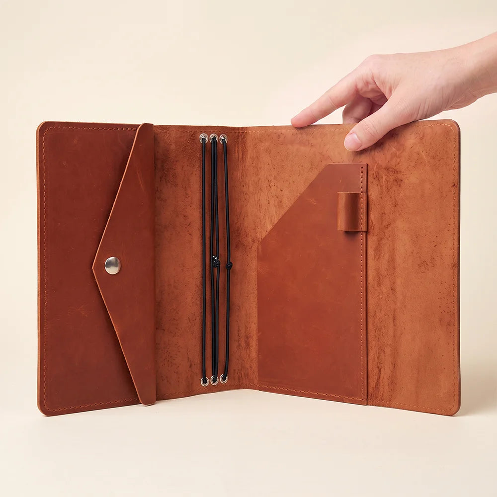 Premium leather travel notebook organizer with secure elastic bands and functional interior storage.