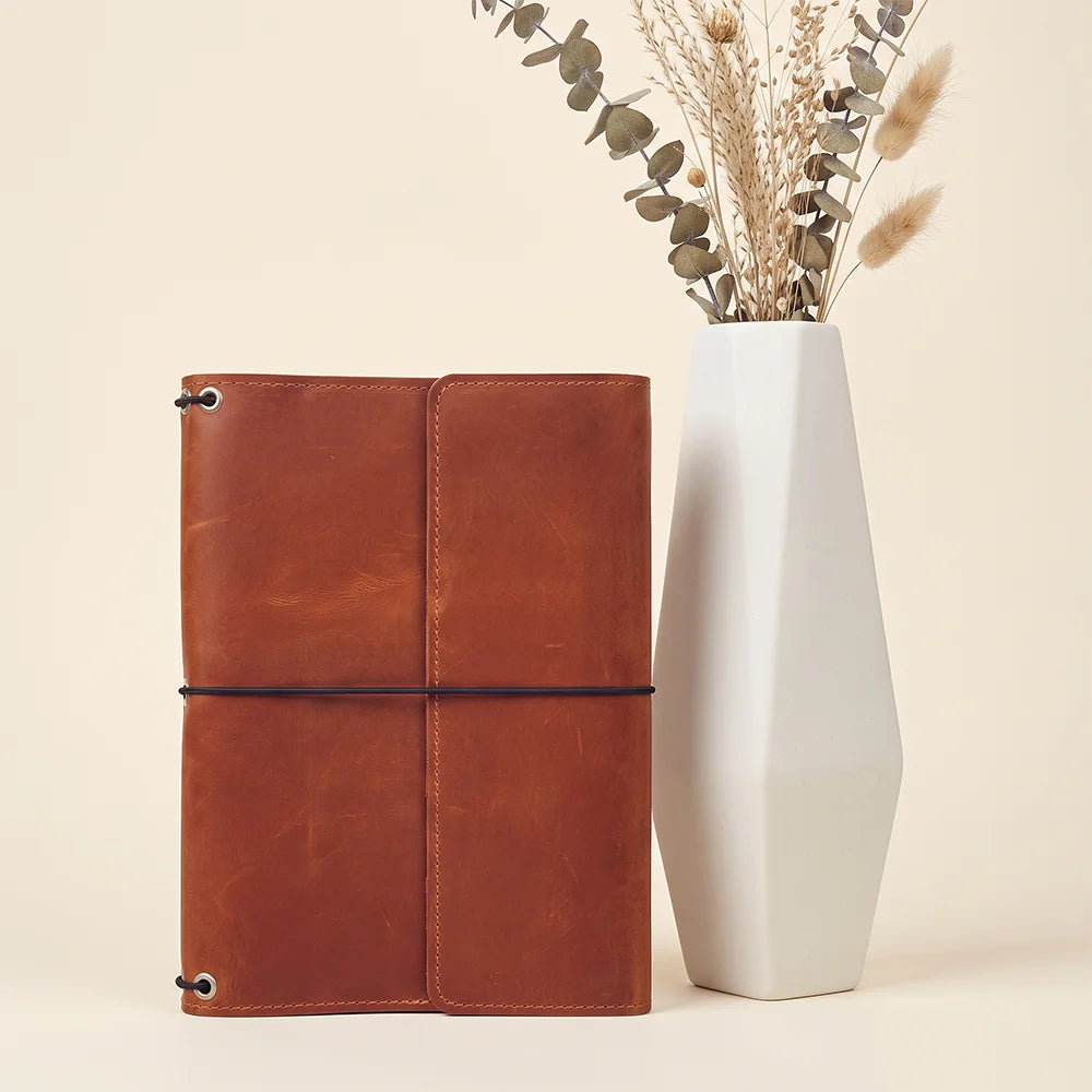 Refillable journal cover crafted from genuine leather with organized storage and elastic closures.
