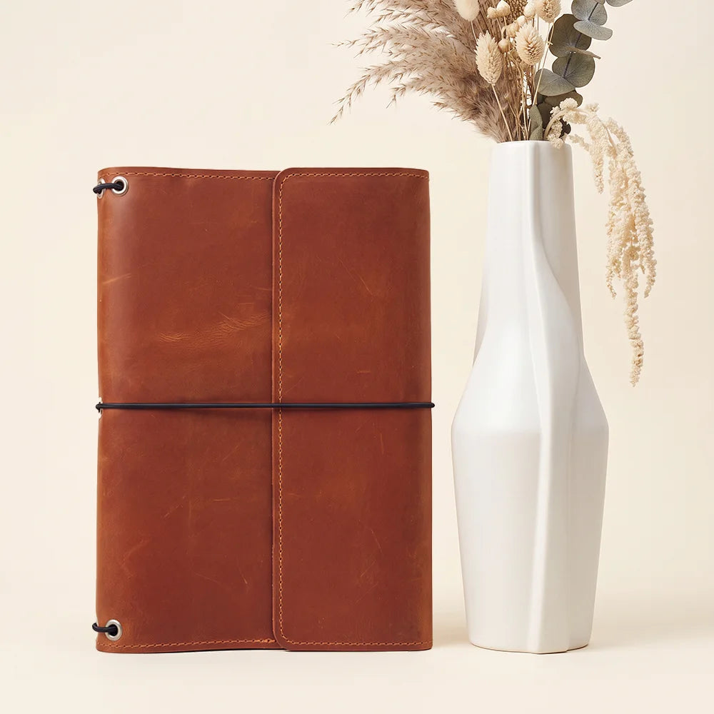 Genuine leather travel journal organizer featuring interior pockets and secure elastic notebook holders.