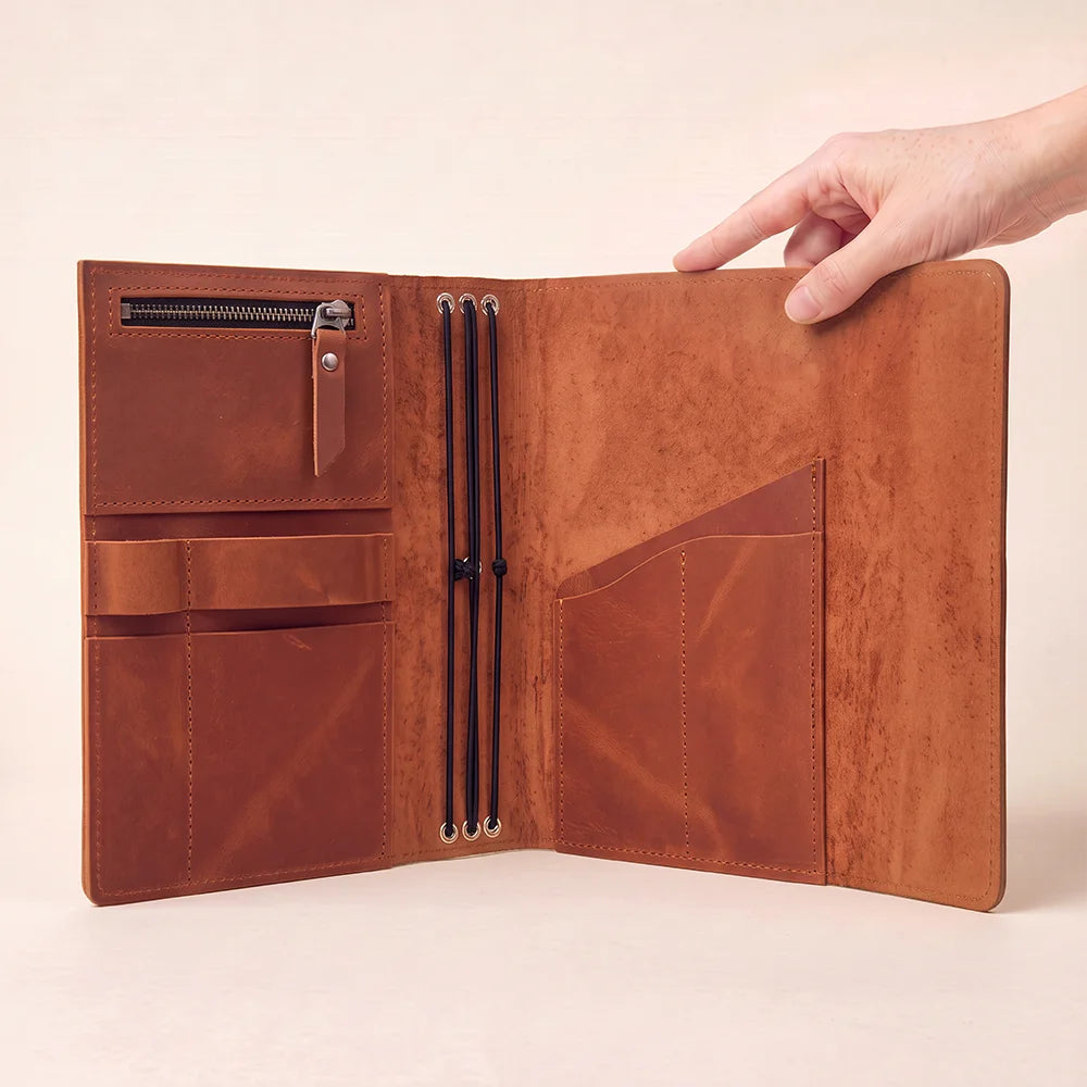 Natural leather notebook holder with thoughtfully designed storage pockets and an attached pen strap.