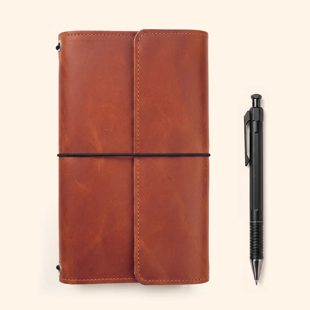 Crafted leather journal cover displaying functional inner compartments and a secure writing utensil loop.