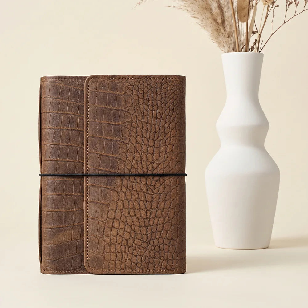 Leather notebook organizer interior with six elastic holders and secure zippered compartment.