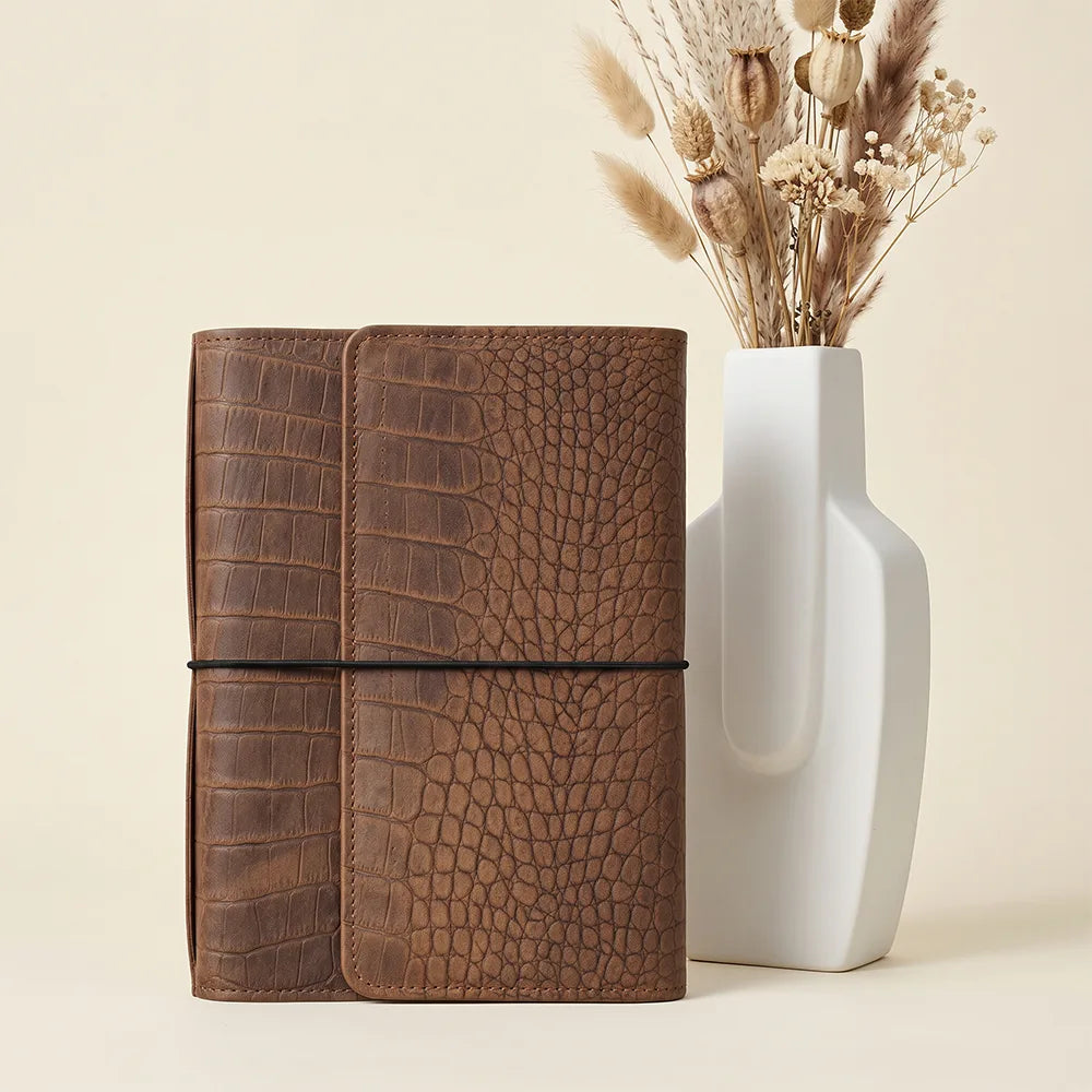 Premium leather notebook organizer featuring six elastic bands and secure zippered storage.