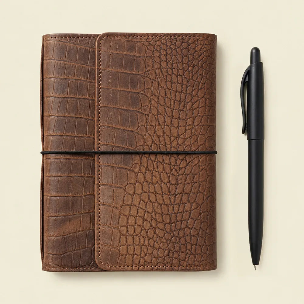 Leather planner cover with multiple small pockets, elastic holders, zipper compartment, and pen loop.