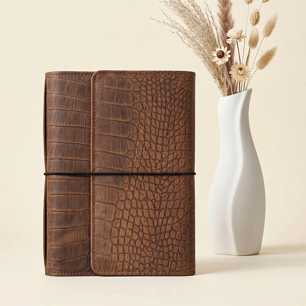 Handmade leather notebook cover featuring six elastic bands and a spacious zippered pocket.